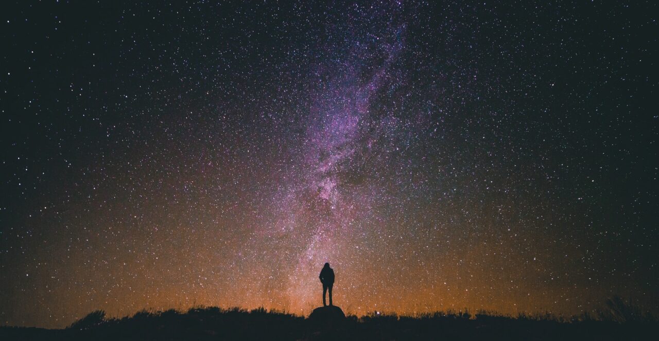 Eine Person schaut in den Nachthimmel und das Universum